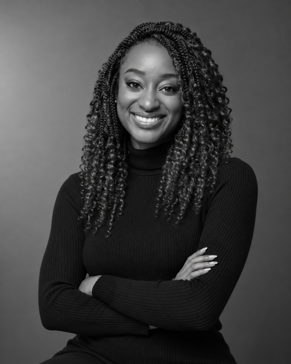 Black-and-white portrait of Shiloh smiling with her arms folded